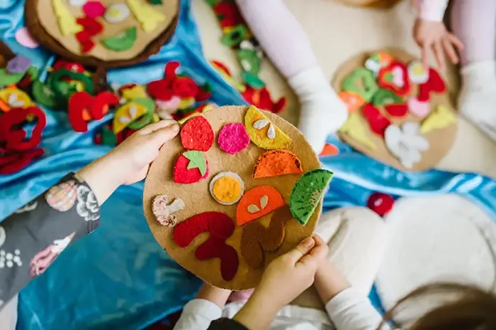 Children playing with homemade felt play food 