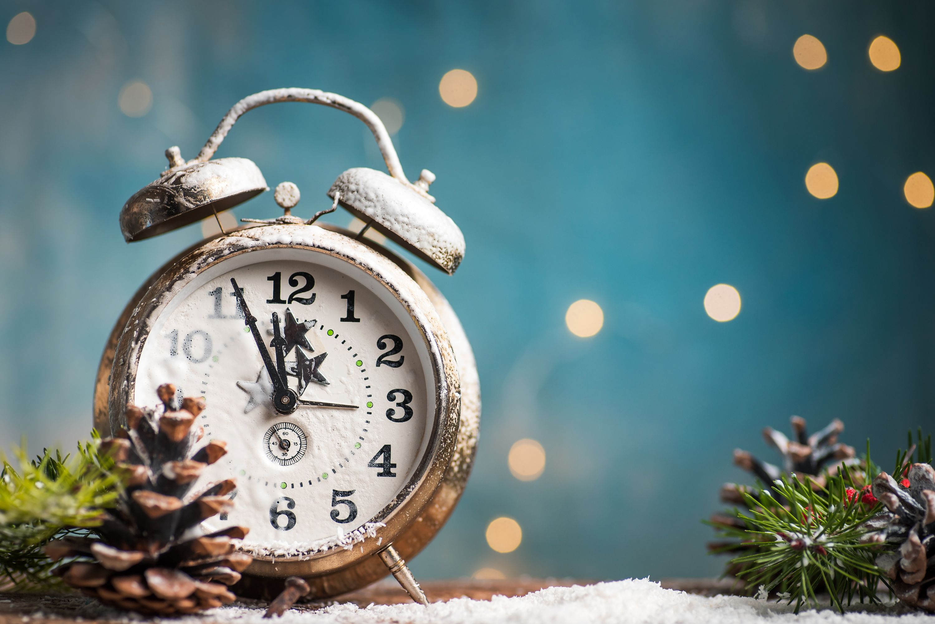 Gold alarm clock in wintery blue background