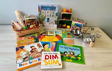 Livres d’histoires sur l’alimentation de diverses cultures, avec de la vaisselle et des jouets en forme d’aliments
