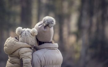 Adulte tenant un enfant dehors en hiver